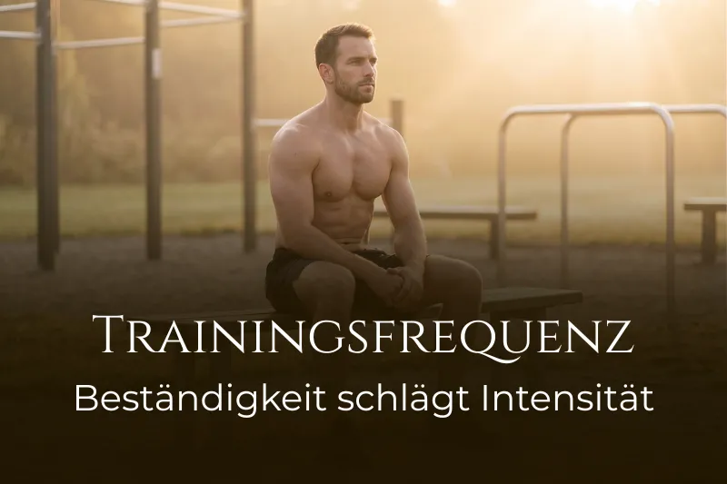 Ein muskulöser Mann sitzt nachdenklich im Calisthenics-Park bei Sonnenaufgang. Bildtitel: 'TRAININGSFREQUENZ Beständigkeit schlägt Intensität'.